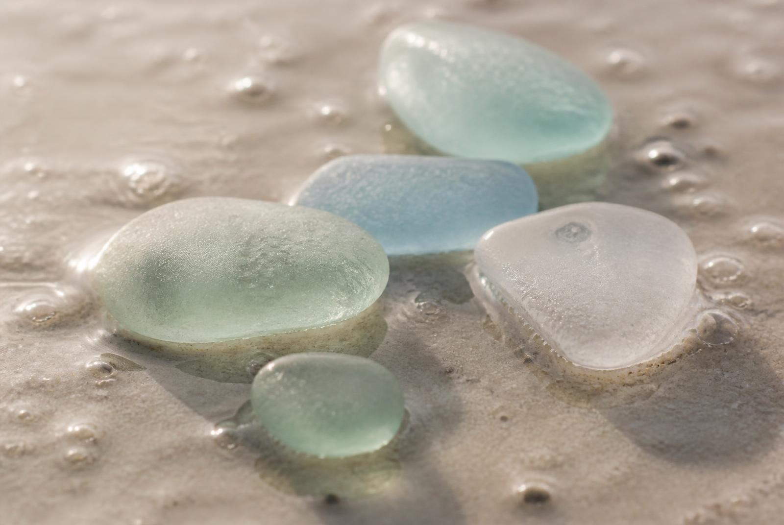 Frosted sea glass resting on wet sand